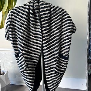 Knit, buttonless throw on. Two front pockets.